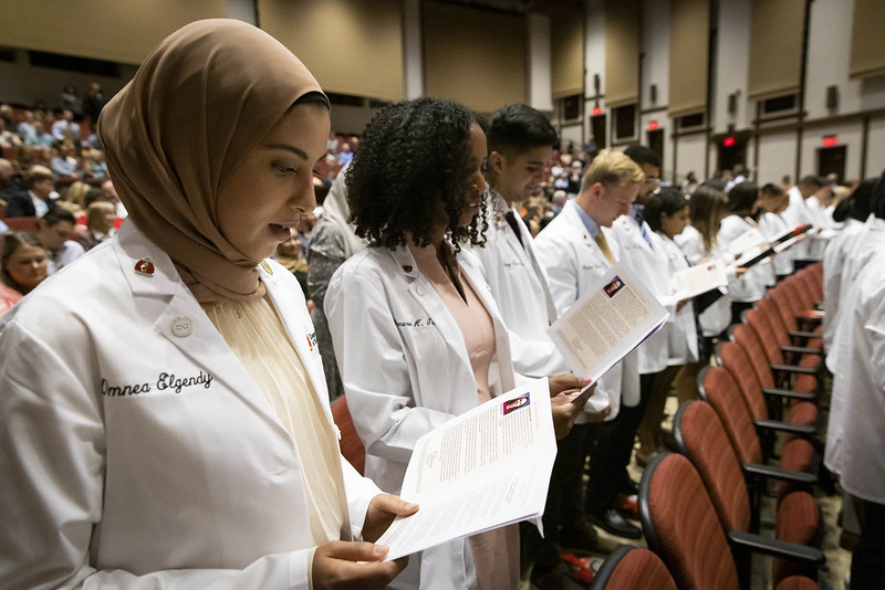 Medical students in white coats at a white coat ceremony 