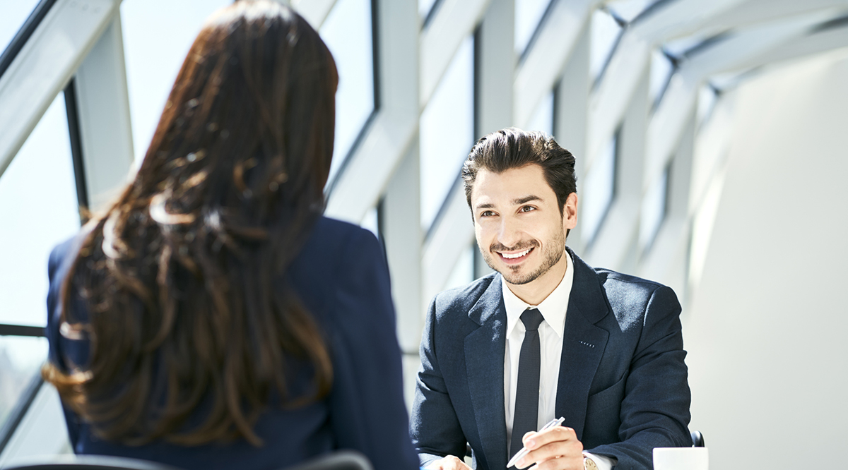 A student wearing a business suit smiles during an interview
