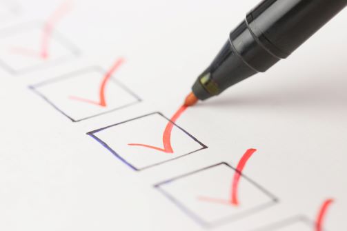 A financial checklist form with orange checkmarks 