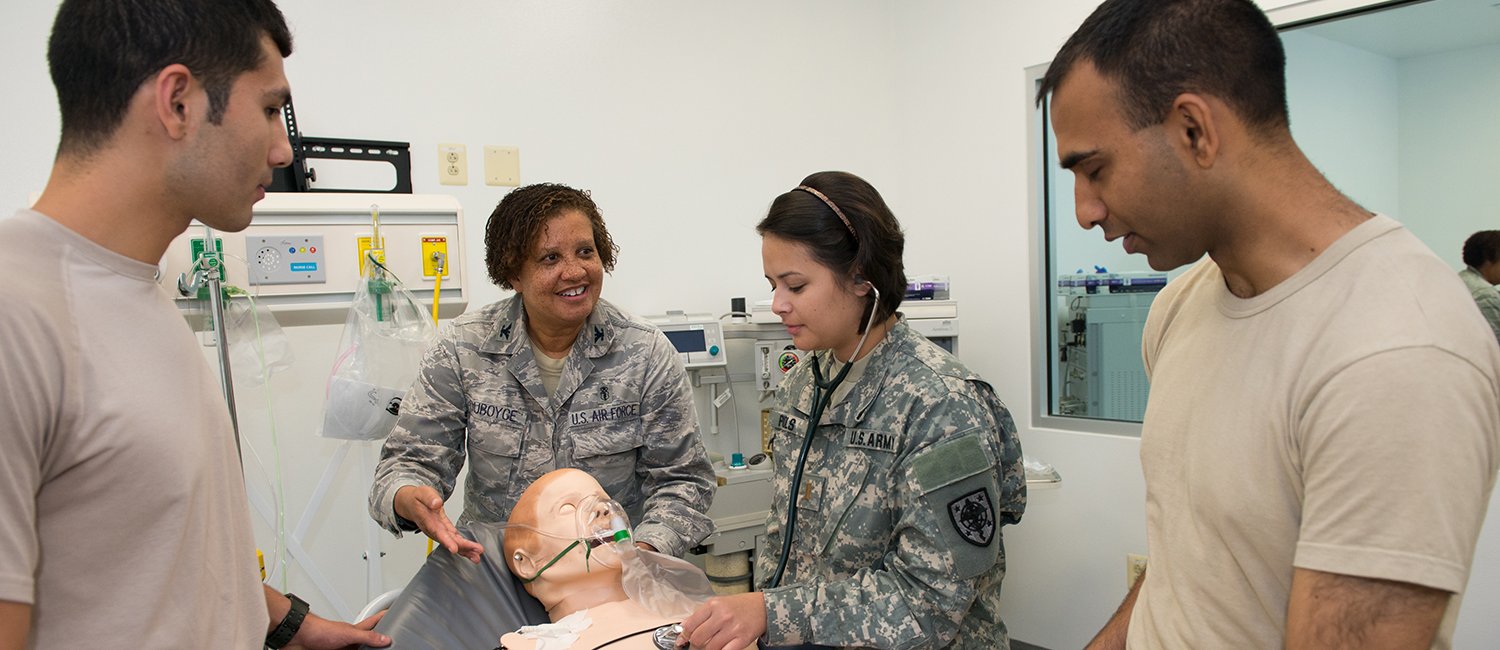 military medical students learn from professor using dummy