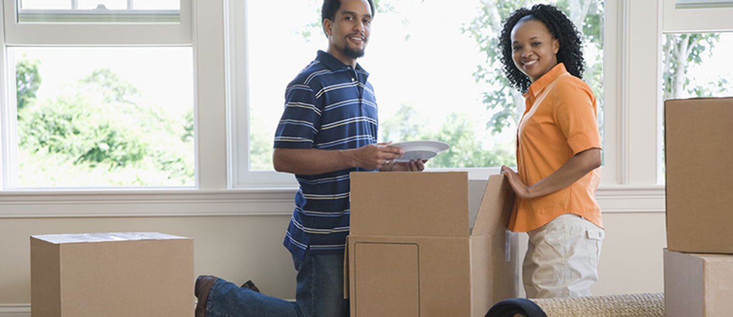 man and woman unpacking box in empty house