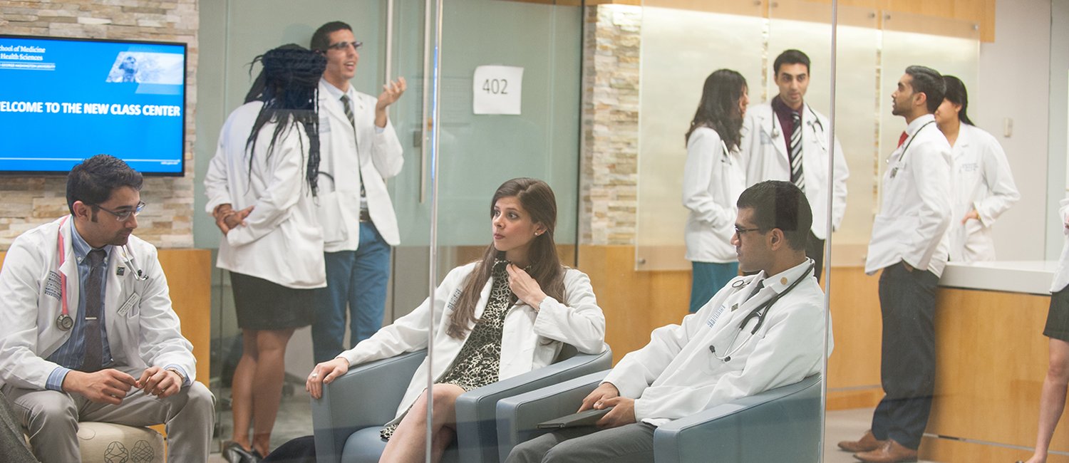 group of medical students conversing in white coats in meeting center  