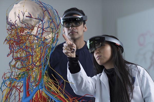 Students wearing HoloLens devices gathered around a 3D model of the body
