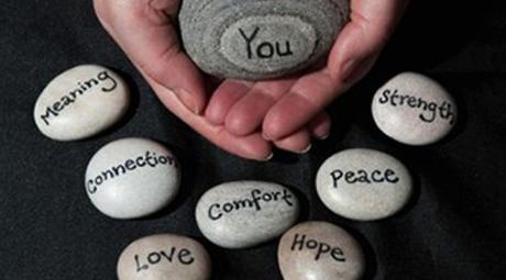 Hands holding a rock that says "You" surrounded by rocks that say "Meaning", "Connection", "Love", "Comfort", "Hope", "Peace", and "Strength"