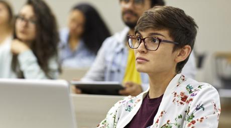 A student with a laptop pays attention in a lecture