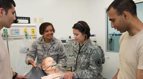 military medical students learn from professor using dummy
