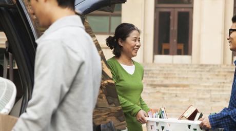Family moving a student into dormitory on college campus 