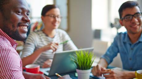 Young people sitting at table, drinking tea and studying