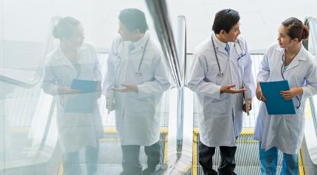 Two doctors on escalator having conversation