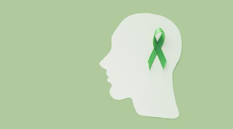 An illustration showing a silhouette of a head in profile with a green ribbon on the side.