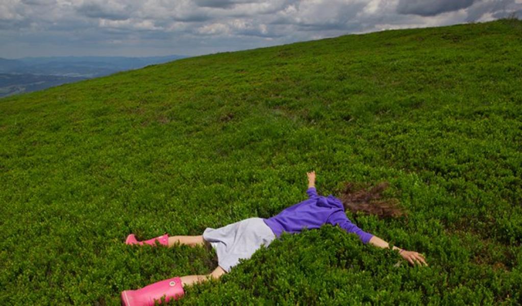 A person laying face down on a grass field