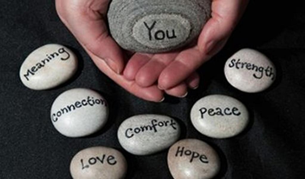Hands holding a rock that says "You" surrounded by rocks that say "Meaning", "Connection", "Love", "Comfort", "Hope", "Peace", and "Strength"