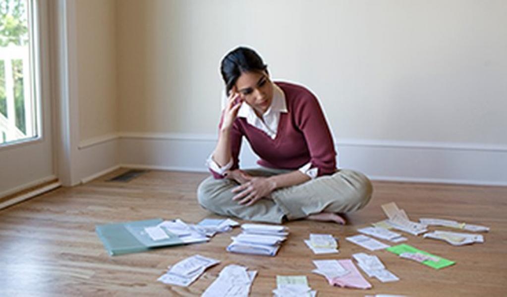 A person looking at bills and receipts on floor