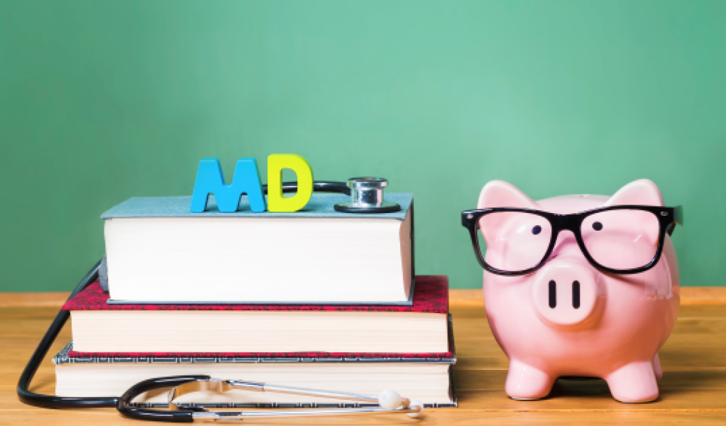 A pink piggy bank with glasses and books