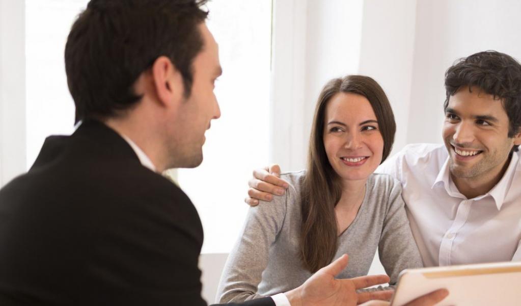 young couple meeting real-estate agent to buy property, presentation tablet