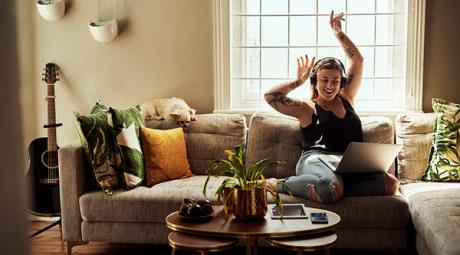 Woman listening to music on laptop while dancing Woman listening to music on laptop while dancing