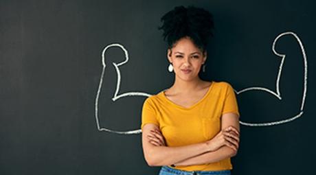 A person posing with a chalk illustration of flexing muscles against a dark background