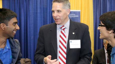 students talking to school rep at a career fair