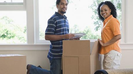 Two people unpacking a moving box