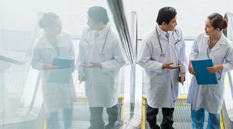 Two doctors on escalator having conversation