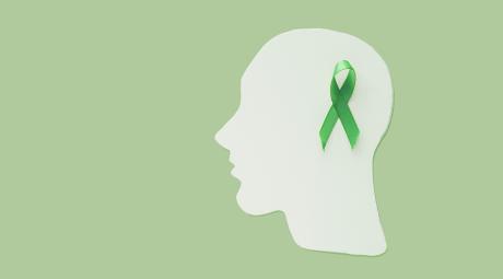 Mental Health Awareness An illustration showing a silhouette of a head in profile with a green ribbon on the side.