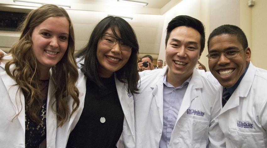 Students pictured in white physician coats 
