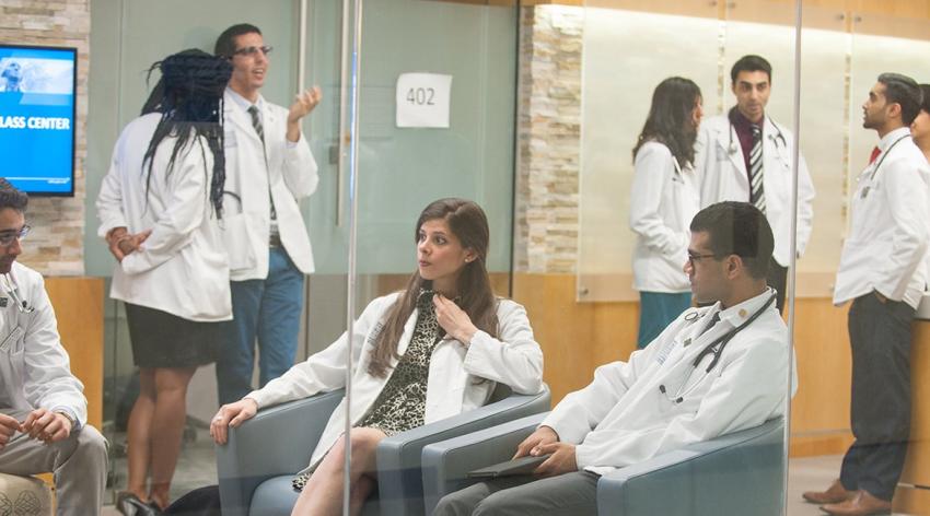 group of medical students conversing in white coats in meeting center  