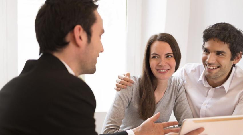 young couple meeting real-estate agent to buy property, presentation tablet