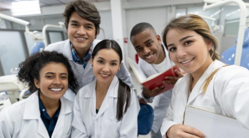 A group of medical students wearing white coats in a laboratory.